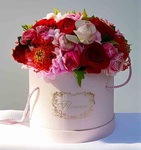 Roses arranged in a pink, stylish flower box.